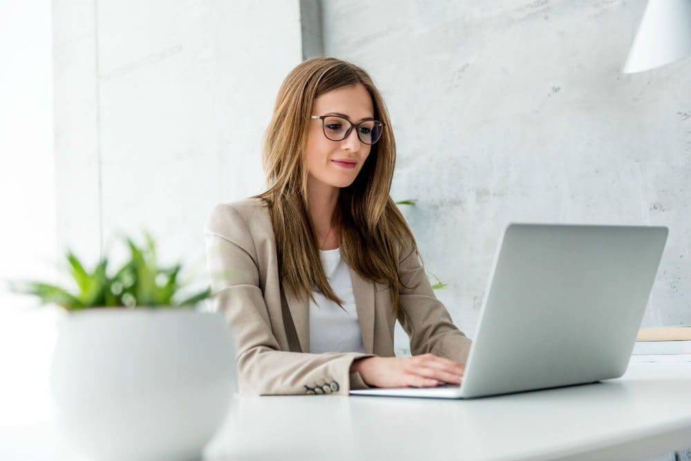 A woman sitting at a table with a laptop.