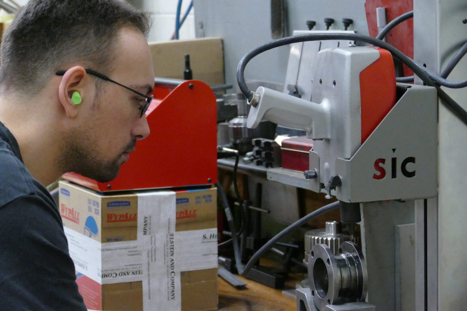 A man wearing ear plugs while using machinery